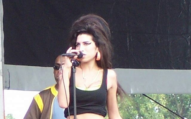 Amy Winehouse in concert, August 2007 (photo credit: CC BY-SA 3.0, by Massic80, Wikimedia Commons)