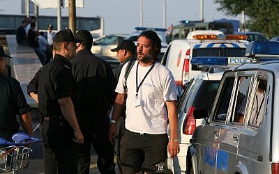 A tourist agency employee reacts as he passes by Bulgarian policemen shortly after a bomb attack against Israeli tourists near Burgas airport, on Wednesday, July 18, 2012 (photo credit: AP/Impact press Group)
