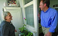 Claims Conference chief Greg Schneider visiting a Nazi victim at her home in Moldova. (Photo credit: Courtesy of Claims Conference/JTA)