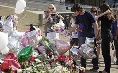 Actor Christian Bale, second right, and his wife Sibi Blazic, right, place flowers on a memorial to the victims of the mass shooting,in Aurora, Colorado. (photo credit: AP Photo/Ted S. Warren)