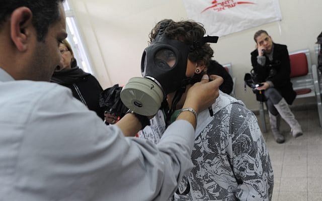 An Israeli child is trying a gas mask, part of a chemical protection kit in a distribution center in 2010. Amid growing fears that terrorist groups may inherit Syria's unconventional weapons Israelis are flocking to distribution centers to receive new gas masks. (photo credit: Gili Yaari/Flash 90)