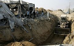 A Caterpillar bulldozer clears the area where a smuggling border tunnel between the Gaza Strip and Egypt was targeted by an Israeli air strike at dawn in Rafah, southern Gaza, on July 14, 2011. (photo credit: Abed Rahim Khatib/Flash90)
