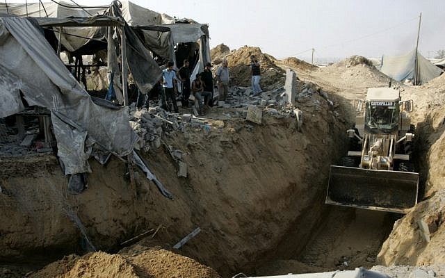 A Caterpillar bulldozer clears the area where a smuggling border tunnel between the Gaza Strip and Egypt was targeted by an Israeli air strike at dawn in Rafah, southern Gaza, on July 14, 2011. (photo credit: Abed Rahim Khatib/Flash90) A Caterpillar bulldozer clears the area where a smuggling border tunnel between the Gaza Strip and Egypt was targeted by an Israeli air strike at dawn in Rafah, southern Gaza, on July 14, 2011. (photo credit: Abed Rahim Khatib/Flash90)