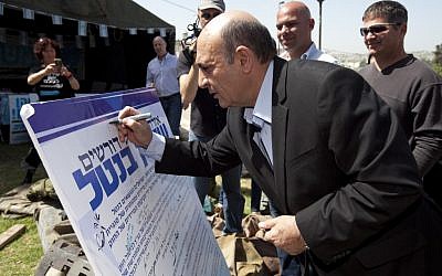 Kadima chairman Shaul Mofaz symbolically signs a petition for universal conscription at the “Suckers’ Tent” in Jerusalem on April 22, 2012. (photo credit: Flash90)