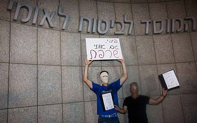 Protesters hold a sign reading 'Bibi you burned me, too' in front of the National Insurance Institute in Tel Aviv in mid-July (photo credit: Tali Mayr/Flash90)
