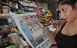A woman reads the free daily Israel Hayom. (Miriam Alster/Flash90)