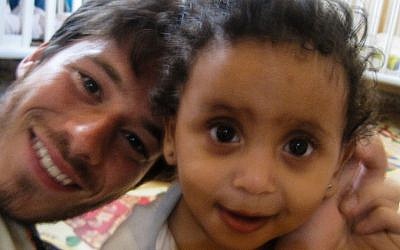 Tyler Fishbone (left) with one of the children from the day care for refugees he volunteered at in the Hatikvah neighborhood in south Tel Aviv (photo credit: courtesy) Tyler Fishbone (left) with one of the children from the day care for refugees he volunteered at in the Hatikvah neighborhood in south Tel Aviv (photo credit: courtesy)