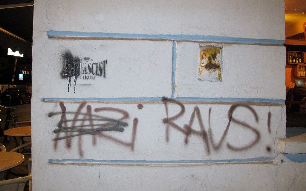 Graffiti on the wall of the Moment cafe in Krakow's Kazimierz Jewish quarter read 'Nazi Raus!' and also cross out the 'anti' in 'anti-Fascist.'  (photo credit: Ruth Ellen Gruber/JTA)