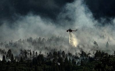 A helicopter drops water on the US Air Force Academy as firefighters battle the blaze in Colorado Springs, Colorado, on June 27, 2012. (photo credit: US Department of Agriculture)