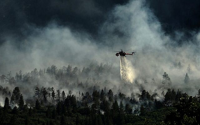 A helicopter drops water on the US Air Force Academy as firefighters battle the blaze in Colorado Springs, Colorado, on June 27, 2012. (photo credit: US Department of Agriculture) A helicopter drops water on the US Air Force Academy as firefighters battle the blaze in Colorado Springs, Colorado, on June 27, 2012. (photo credit: US Department of Agriculture)