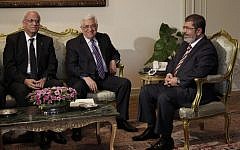 Palestinian Authority President Mahmoud Abbas, center, with Egyptian President Mohammed Morsi, right, at their first meeting in Cairo in July 2012. (photo credit: Maya Alleruzzo/AP)