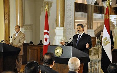 Tunisian President Moncef Marzouki, left, listens as Egyptian President Mohammed Morsi, right, speaks to reporters during a joint news conference at the Presidential palace in Cairo on Friday. (photo credit: AP/Egyptian Presidency)