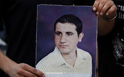 A Palestinian Christian holds a poster of Ramez Al-Amash, 25, during a rally at a Greek Orthodox church in Gaza City, in July (photo credit: AP/Adel Hana)