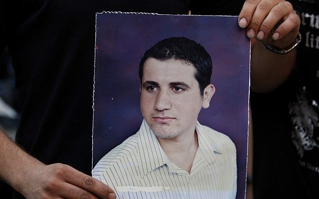 A Palestinian Christian holds a poster of Ramez Al-Amash, 25, during a rally at a Greek Orthodox church in Gaza City, in July (photo credit: AP/Adel Hana)