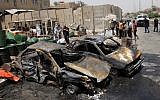 People inspect the aftermath of a car bomb attack in Baghdad on Monday. (photo credit: AP /Karim Kadim)
