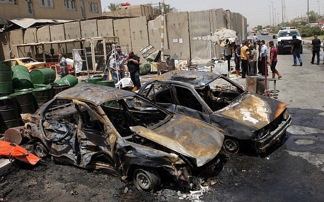 People inspect the aftermath of a car bomb attack in Baghdad on Monday. (photo credit: AP /Karim Kadim) People inspect the aftermath of a car bomb attack in Baghdad on Monday. (photo credit: AP /Karim Kadim)