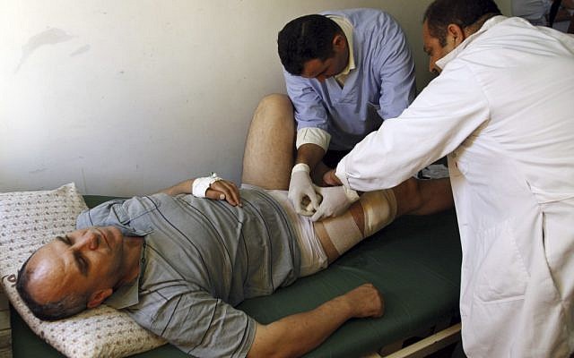 Palestinian lawmaker Shami Al-Shami, 47, is treated by medics for gun wounds sustained outside his home in the West Bank town of Jenin, Sunday, July 1 (photo credit: AP/Mohammed Ballas)