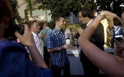 Gilad Shalit, center, mingles and speaks to the French Ambassador to Israel Christophe Bigot, in Tel Aviv Thursday. (photo credit: Ariel Schalit/AP)