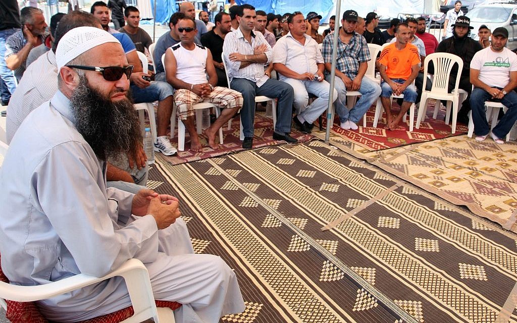 Sheik Ahmad Assir, left, receives a group of supporters who came from the northern city of Tripoli to a protest camp he set in the southern port city of Sidon, Lebanon (photo credit: AP/Bilal Hussein) Sheik Ahmad Assir, left, receives a group of supporters who came from the northern city of Tripoli to a protest camp he set in the southern port city of Sidon, Lebanon (photo credit: AP/Bilal Hussein)