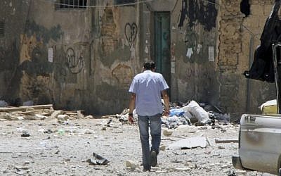 A man walks along a shattered street in Damascus on Friday (photo credit: AP/Bassem Tellawi)