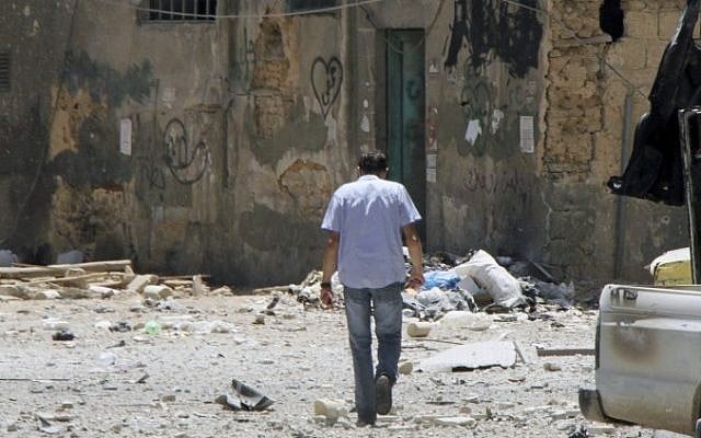 A man walks along a shattered street in Damascus on Friday (photo credit: AP/Bassem Tellawi)