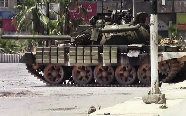 This image made from amateur video released by the Shaam News Network and accessed Sunday, shows a Syrian military tank in Daraa, Syria. (Photo credit: AP/Shaam News Network)
