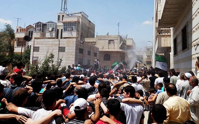 Syrians chanting slogans during a demonstration in Hama (photo credit: AP/Shaam News Network, SNN)