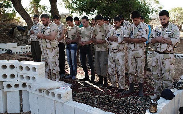 Free Syrian Army soldiers pray at the northern town of Sarmada, Syria, on Monday (photo credit: AP/Shaam News Network) Free Syrian Army soldiers pray at the northern town of Sarmada, Syria, on Monday (photo credit: AP/Shaam News Network)