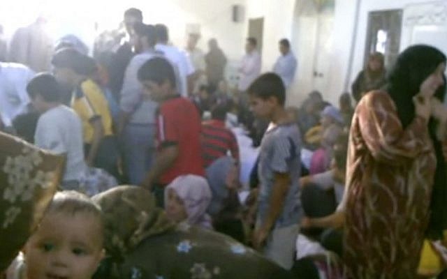 This image made from amateur video accessed by AP on Friday purports to show families gathered around bodies of victims killed by violence that, according to anti-regime activists, was carried out by government forces in Tremseh, Syria. (photo credit: AP/Hama Revolution 2011) This image made from amateur video accessed by AP on Friday purports to show families gathered around bodies of victims killed by violence that, according to anti-regime activists, was carried out by government forces in Tremseh, Syria. (photo credit: AP/Hama Revolution 2011)