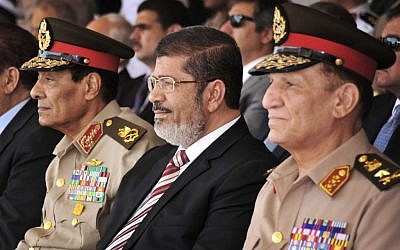 Egyptian President Mohammed Morsi flanked by high-ranking generals (photo credit: AP/Mohammed Abd El Moaty)