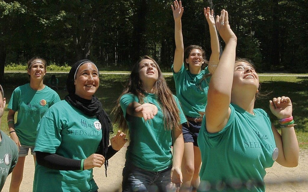 Jordanian, Egyptian, and Israeli girls work and play together as a team during a game of volleyball at the Seeds of Peace summer camp in Otisfield, Maine. (photo credit: Robert F. Bukaty/AP)