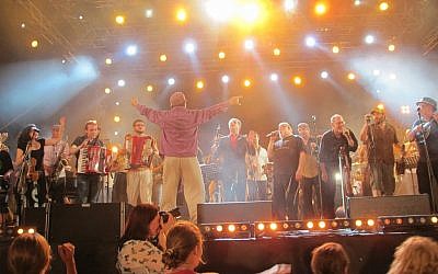 Klezmer star Frank London, with his back to the camera, conducting the participants of the 'Shalom' concert at the Jewish Culture Festival in Krakow, Poland, June 2012. (photo credit: Ruth Ellen Gruber/JTA)