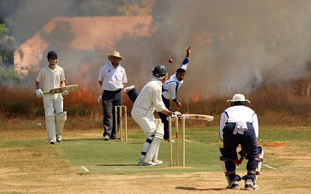 Smoke blows toward the pitch at Lod, shortly before play was suspended on Friday. (photo credit: David Z Harris)