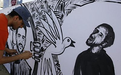 Palestinian painters paint murals of Mahmoud Sarsak (R) and other prisoners, in the southern Gaza Strip on June 10, 2012. Sarsak, a former member of the Palestinian National Soccer Team, was released after three-month hunger strike. (photo credit: Abed Rahim Khatib/Flash 90)