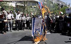 Iranian demonstrators burn an Israeli and British flag during an annual pro-Palestinian rally marking Quds (Jerusalem) Day, on the last Friday of the holy month of Ramadan, at the Enqelab-e-Eslami (Islamic Revolution) St. in Tehran, August 17, 2012 (photo credit: AP Photo/Vahid Salemi)