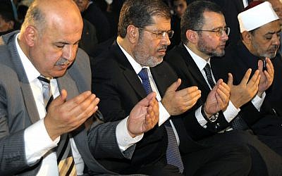 Egyptian President Mohammed Morsi prays alongside members of his cabinet during the festival of Eid Al-Fitr (photo credit: AP/Egyptian Presidency)
