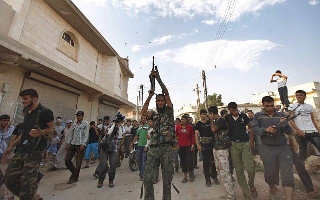 Syrian fighters during a funeral near Aleppo on Thursday. (photo credit: AP/Khalil Hamra)