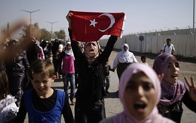 Syrian women and girls shout slogans on Tuesday as they march toward the border, pleading for entry into neighboring Turkey (photo credit: AP/Muhammed Muheisen)