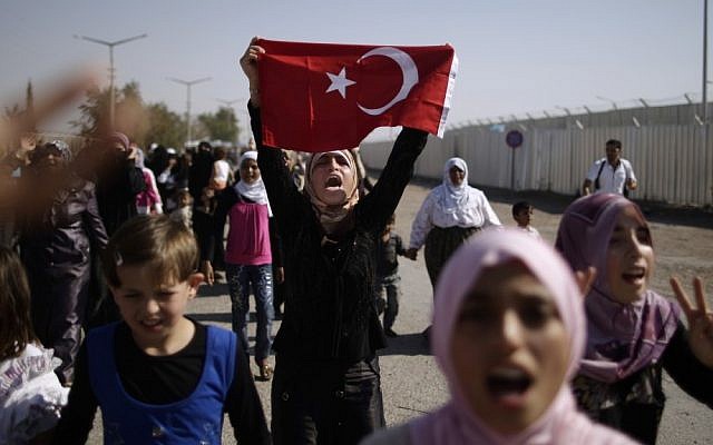 Syrian women and girls shout slogans on Tuesday as they march toward the border, pleading for entry into neighboring Turkey (photo credit: AP/Muhammed Muheisen)