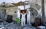 A Syrian man standing in front of his house, which was destroyed by Syrian government forces shelling in Azaz, on the outskirts of Aleppo, August 28, 2012 (photo credit: AP/Muhammed Muheisen)