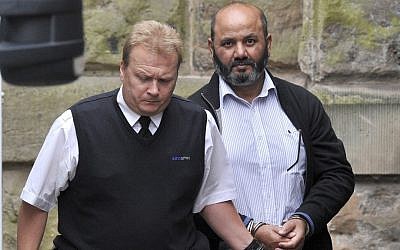 Iftikhar Ahmed, the father of murdered teenager Shafilea Ahmed being escorted into a British court on Friday Aug. 3, 2012 (photo credit: AP/Martin Rickett/PA)