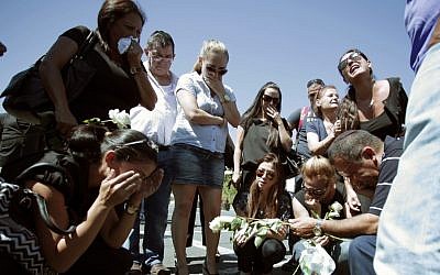 Relatives of five Israeli victims of a suicide bomber who targeted a bus of Israeli tourists a month earlier, mourn during a commemoration ceremony at Burgas airport, Bulgaria Wednesday. (photo credit: AP)