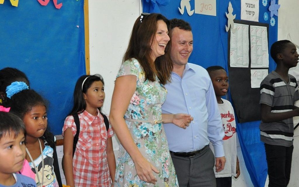 Britain's ambassador to Israel, Matthew Gould, and his wife, Celia, with some of the students of the Bialik-Rogozin school Tuesday. The British embassy hosted an Olympics celebration at the school and the kids, in turn, showed the ambassador how to play the Wii. (photo credit: Michal Shmulovich/Times of Israel) Britain's ambassador to Israel, Matthew Gould, and his wife, Celia, with some of the students of the Bialik-Rogozin school Tuesday. The British embassy hosted an Olympics celebration at the school and the kids, in turn, showed the ambassador how to play the Wii. (photo credit: Michal Shmulovich/Times of Israel)