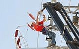 An Israel Electric Corporation employee working on an electric line. (Roni Schutzer/Flash90)