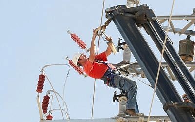 An Israel Electric Corporation employee working on an electric line. (Roni Schutzer/Flash90)