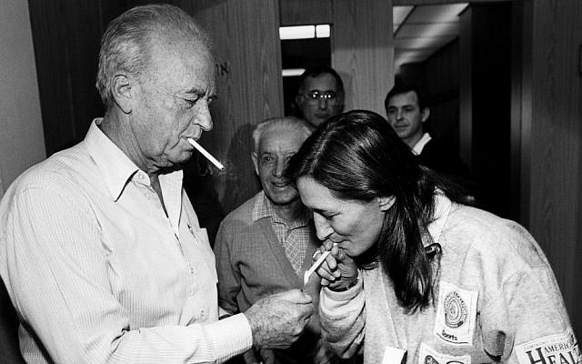 Late Israeli prime minister Yitzhak Rabin lights the cigarette of Yael Dayan, the daughter of former IDF chief of staff Moshe Dayan. (file photo; photo credit: Moshe Shai/Flash90)