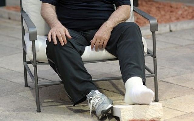 Prime Minister Benjamin Netanyahu sits in the garden of his Jerusalem residence, 11 June 2012, after he injured his leg playing soccer earlier that day with Jewish and Arab youth in Jerusalem. The cast was put up for auction on the Internet in August. (photo credit: GPO/Flash90)