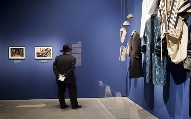 Visitors looking at photographs displayed at the Israel Museum exhibition "A World Apart Next Door: Glimpses into the life of Hasidic Jews" in Jerusalem on June 20, 2012. The ethnographic exhibition highlights facets of the culture of the Hasidic Jews. (photo credit: Yonatan Sindel/Flash90)