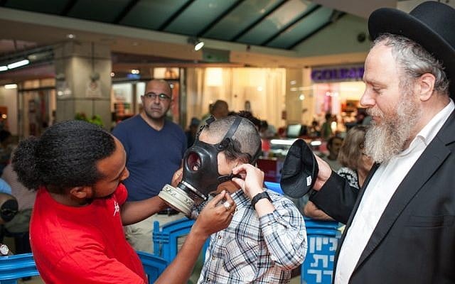 Israeli postal workers distribute gas masks to residents of Jerusalem last month (photo credit: Noam Moskowitz/Flash90)