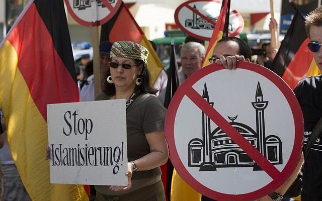 Demonstrators display signs with crossed-out mosques during a protest in front of a mosque in Berlin, Germany, Saturday. (photo credit: AP)